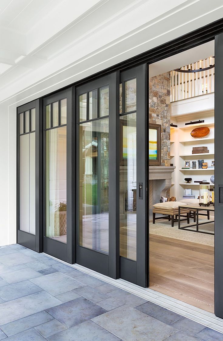 Multi-slide glass patio door opening from a living room onto a stone patio